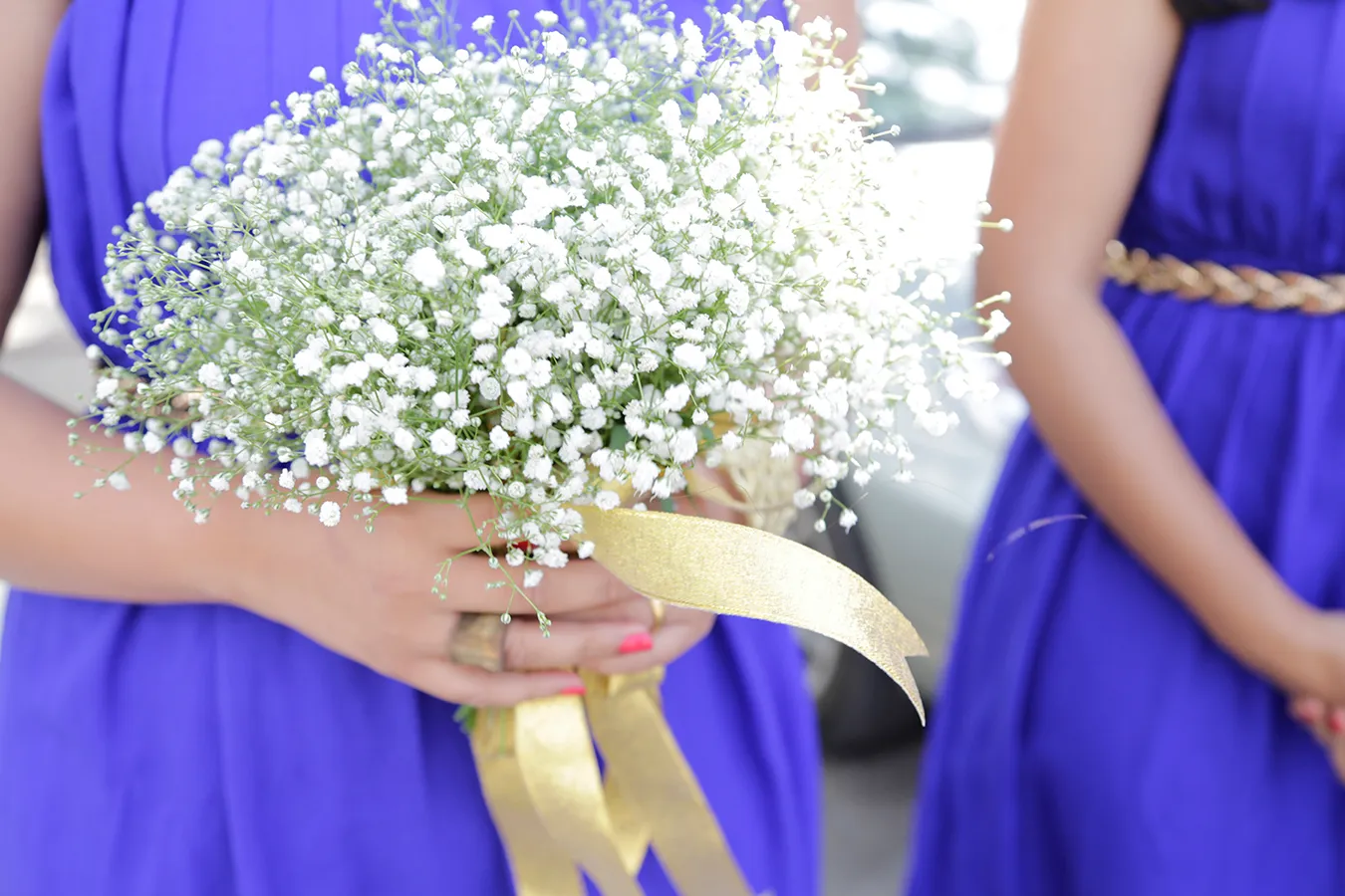 A Bouquet of delicate white flowers being held by a bridesmaid at a Christian wedding in Bengaluru shot by The Knot in Frames