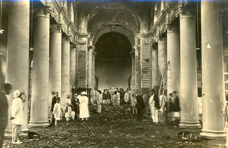 Several people stand around pillars of St. Mark's cathedral in Bengaluru after a fire raged through it in 1923 caused by a short circuit.