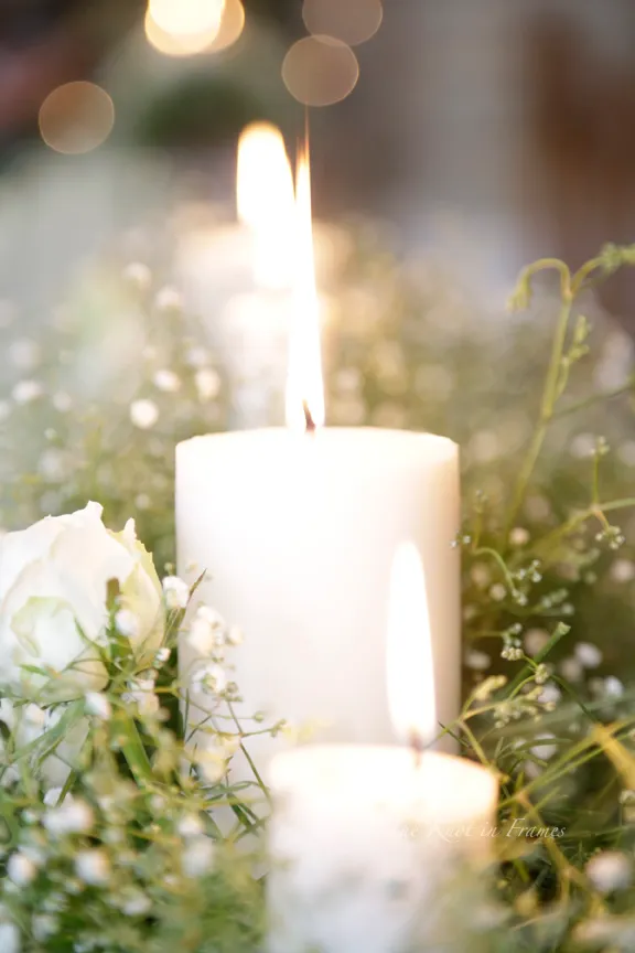 A burning candle amid some beautiful flowers in the Church